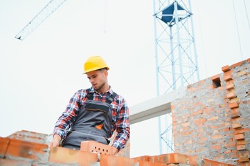 Construction worker man in work clothes and a construction helmet. Portrait of positive male...