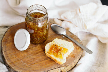 Food still life, a jar of delicious jam smeared on a bun.