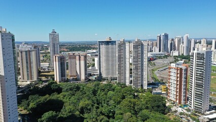 Fototapeta premium Wonderful panoramic view of Flamboyant Park with lakes and tropical trees surrounded by modern residential apartments in Goiania, Goias, Brazil in April, 2023. 