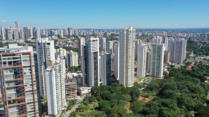 Fototapeta premium Wonderful panoramic view of Flamboyant Park with lakes and tropical trees surrounded by modern residential apartments in Goiania, Goias, Brazil in April, 2023. 