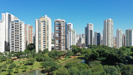 Fototapeta premium Wonderful panoramic view of Flamboyant Park with lakes and tropical trees surrounded by modern residential apartments in Goiania, Goias, Brazil in April, 2023. 