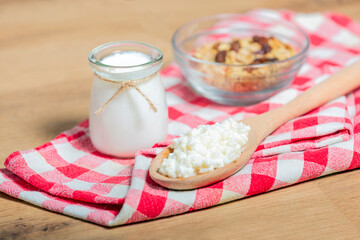 probiotic milk kefir grains, Tibetan mushrooms on wooden spoon, kefir milk in glass containers and...