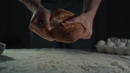 baker holding fresh baked bread with crispy crust worker traditional bakery