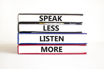 Speak less listen more symbol. Concept words Speak less listen more on books. Beautiful white table...