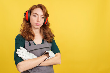Serious redheaded female worker standing with arms crossed