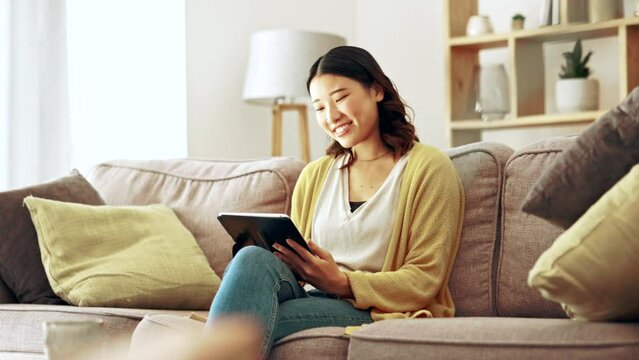 Happy woman, tablet and home on social media, reading ebook and online website application. Asian female, digital technology and connection in house for networking, search internet and download games