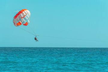 people spend active leisure during holidays at sea, paragliding over water