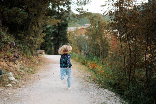 petite fille court sur le chemin lors de ses vacances d'été à la montagne