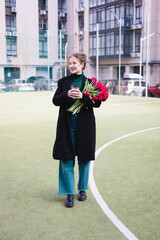 Fototapeta premium girl with a huge bouquet of red tulips