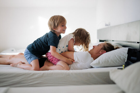 enfants jouent sur le lit avec leurs parents