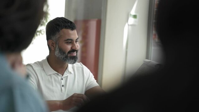 Happy Indian business man doing showing charts and statistics to employees in a company meeting 