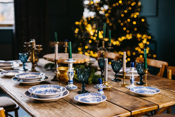 Decorated table for a Christmas party with a Christmas tree in the background.