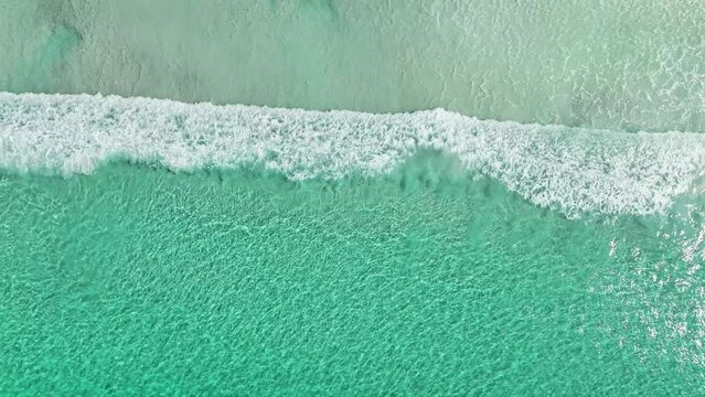 Aerial view of waves rolling on the beach along the shoreline at Cape Le Grand bay, Western Australia, Australia.
