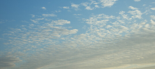 Piękne biało-niebieskie chmury podczas delikatnie zachodzącego słońca