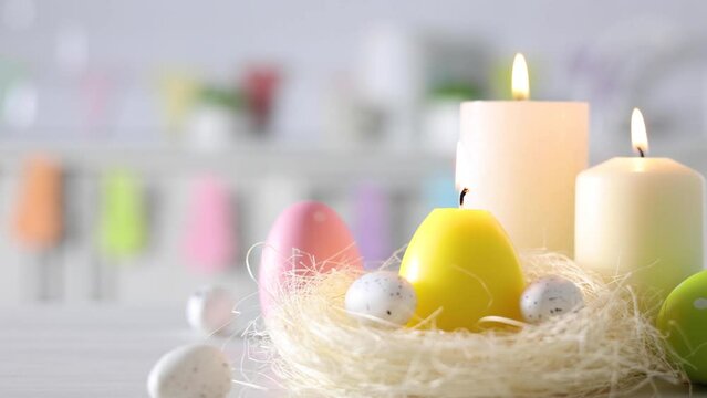 Easter decoration with candles and colorful eggs in the kitchen interior. Easter background