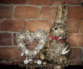Hare and heart for Easter holidays with eggs against background of wall with bricks