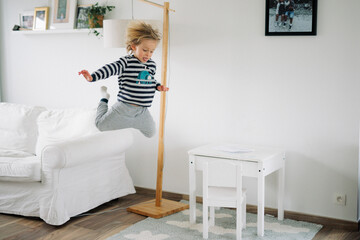 jeune gar&ccedil;on saute du divan