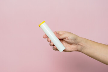 Hand holding bottle for pills, effervescent tablets or vitamin
