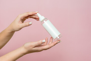 Cosmetic bottle in woman's hands. Cosmetic product branding mockup. Spa beauty treatment concept