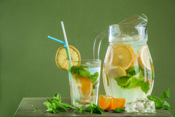 summer refreshing drink with lemon and ice in a decanter
