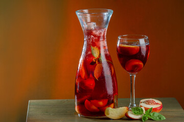 sangria summer refreshing drink with wine red apricot mint and ice in a decanter