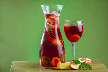 sangria summer refreshing drink with wine red apricot mint and ice in a decanter