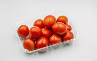 Small cherry tasty fresh red tomatoes closeup on white