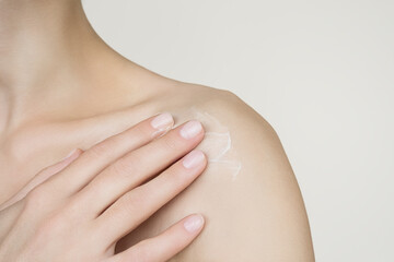 a woman applies moisturizing lotion to the body. skin care concept
