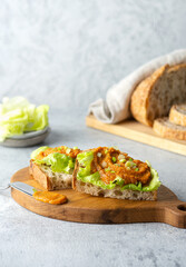 Fried bruschetta with vegetable zucchini caviar, lettuce and onion on a cutting board. Diet vegan food concept.