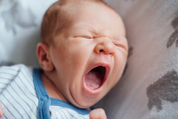 Portrait of a newborn baby yawning