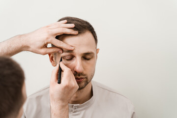 Blepharoplasty for man markup on the face before plastic surgery operation for modifying the eye region in medical clinic.