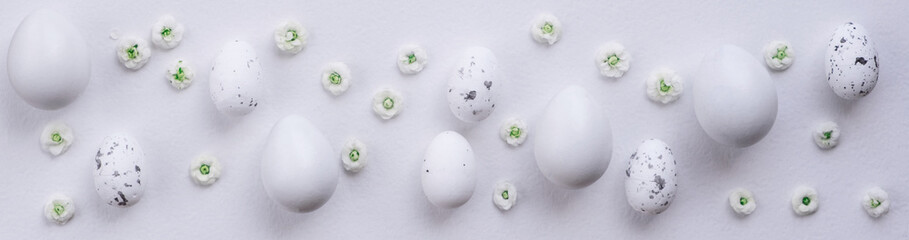 Flat lay easter banner with spring flowers and eggs on white background. Flat lay, top view, copy space.