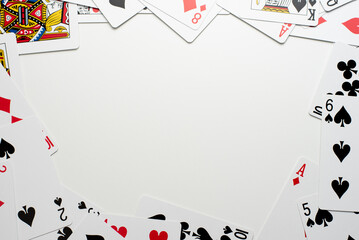Scattered Playing Cards Bordering the Edges of a White Background - Powered by Adobe
