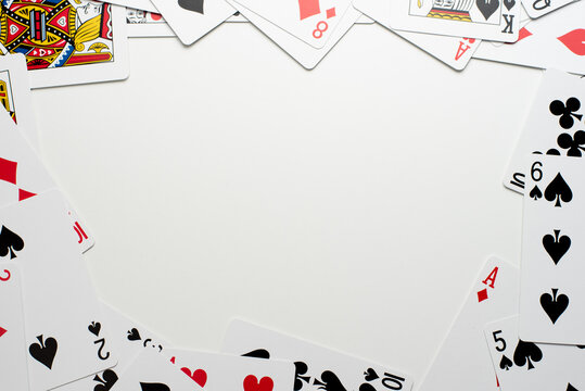 Scattered Playing Cards Bordering the Edges of a White Background