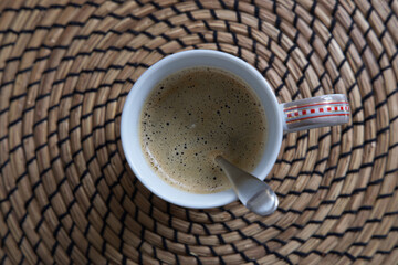Tasse mit Kaffee gefüllt auf einem Platzset