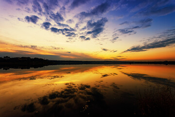 Fototapeta na wymiar Magnificent Lake Sunset with Perfect Cloud Reflections in the Water