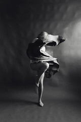 Plakat Elegant Contemporary Dance. Contemp Dancer in weightless skirt over the paper backdrop in studio. Woman dancing in Evening Silk Gown flying on Wind. Black and white image