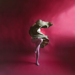 Elegant Contemporary Dance. Contemp Dancer in olive green weightless skirt over the red backdrop in studio. Woman dancing in Evening Silk Gown flying on Wind