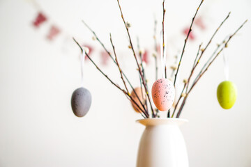 Easter decoration with a bouquet of the willow branches with colored eggs. Happy Easter and spring.