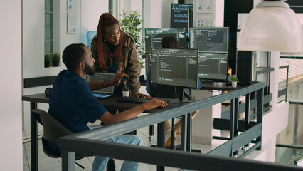 African american team of developers talking about source code running on screen, analyzing server...