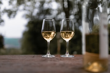 Two glasses of wine on table outdoors  
