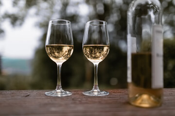 Two glasses of wine on table outdoors 