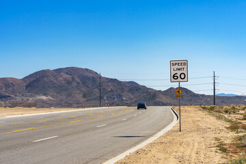 A 60 Speed Limit street sign on a on rural road in the Mojave Desert in California