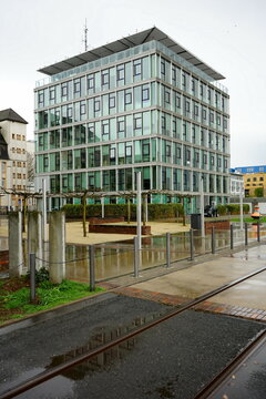 Heinz-Raspe-Platz mit Platanen und moderner Architektur bei Regen an der Lindleystra&szlig;e und dem Main Riedgraben im Ostend von Frankfurt am Main in Hessen