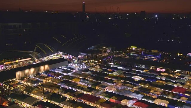 Panning over sunset in Bangkok, Thailand, and colorful night market. 
