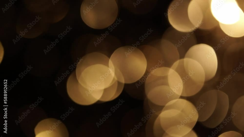 Wall mural gold sepia bokeh shimmering on black. abstract overflow movement of defocused circles in sepia tones