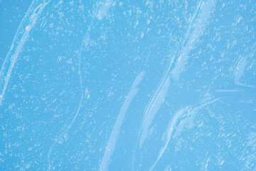 Glossy smudges and smudges of blue cosmetic fluid with bubbles.