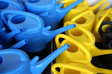 Gießkannen in Blau und Gelb aus Plastik und Kunststoff vor einem Geschäft in Rosenthal im...