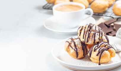 Homemade profiteroles with whipped cream and chocolate filling, horizontal, copy space