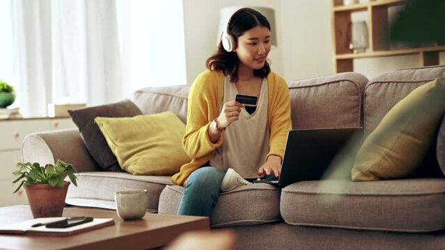 Relax, online shopping and a woman with a credit card and laptop for payment and ecommerce. Headphones, music and Asian girl with information to pay for a web or retail service on a computer